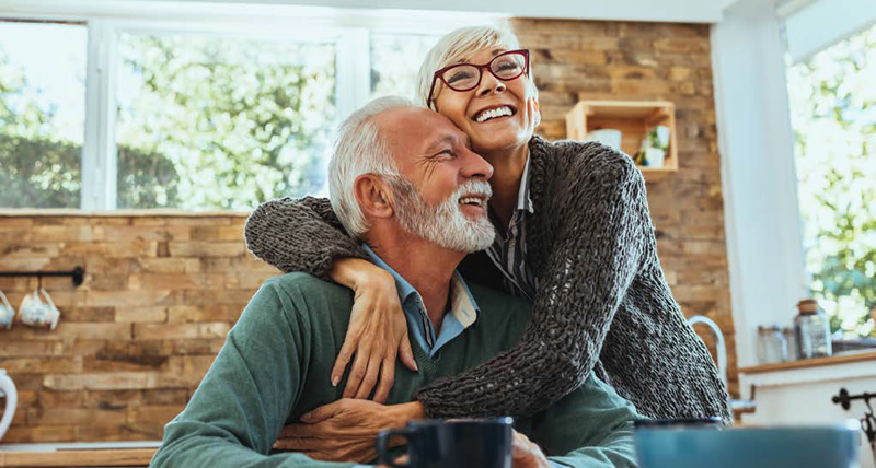 older man and woman holding each other and smiling